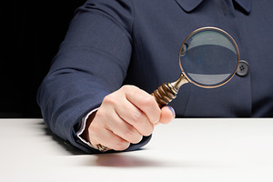 A woman's hand in a blue jacket holds an antique magnifying glas, a Person Photo by ndanko