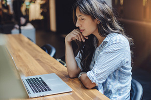 Business woman working on laptop containing laptop, woman, and using
