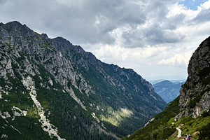 Hikers on a winding mountain trail in Zakopane, Poland under dramatic clouds, a Nature Photo by AS photostudio