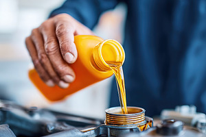 Pouring engine oil into a vehicle's engine for maintenance and smooth operation, a Photo by AlyaAnd