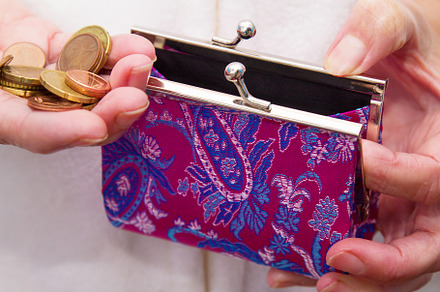 Hand with coins saving on wallet containing savings, retirement, and old