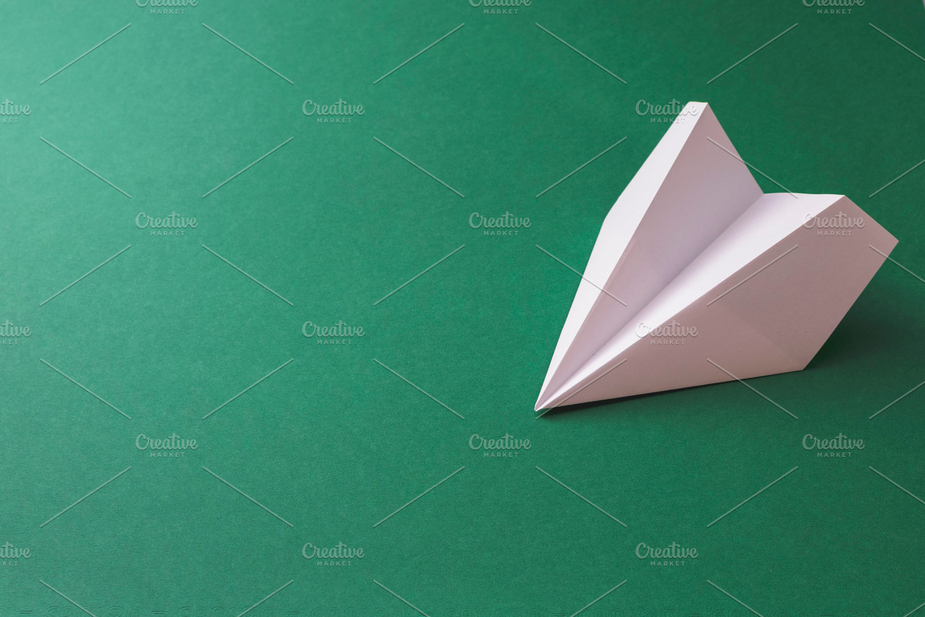 Paper plane on dark green background, a Transportation Photo by Ti-Di