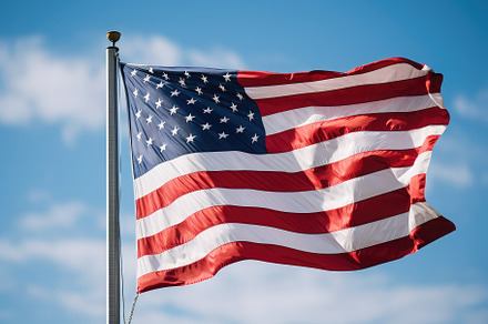 American flag waving proudly in the, a Photo by SaroStock