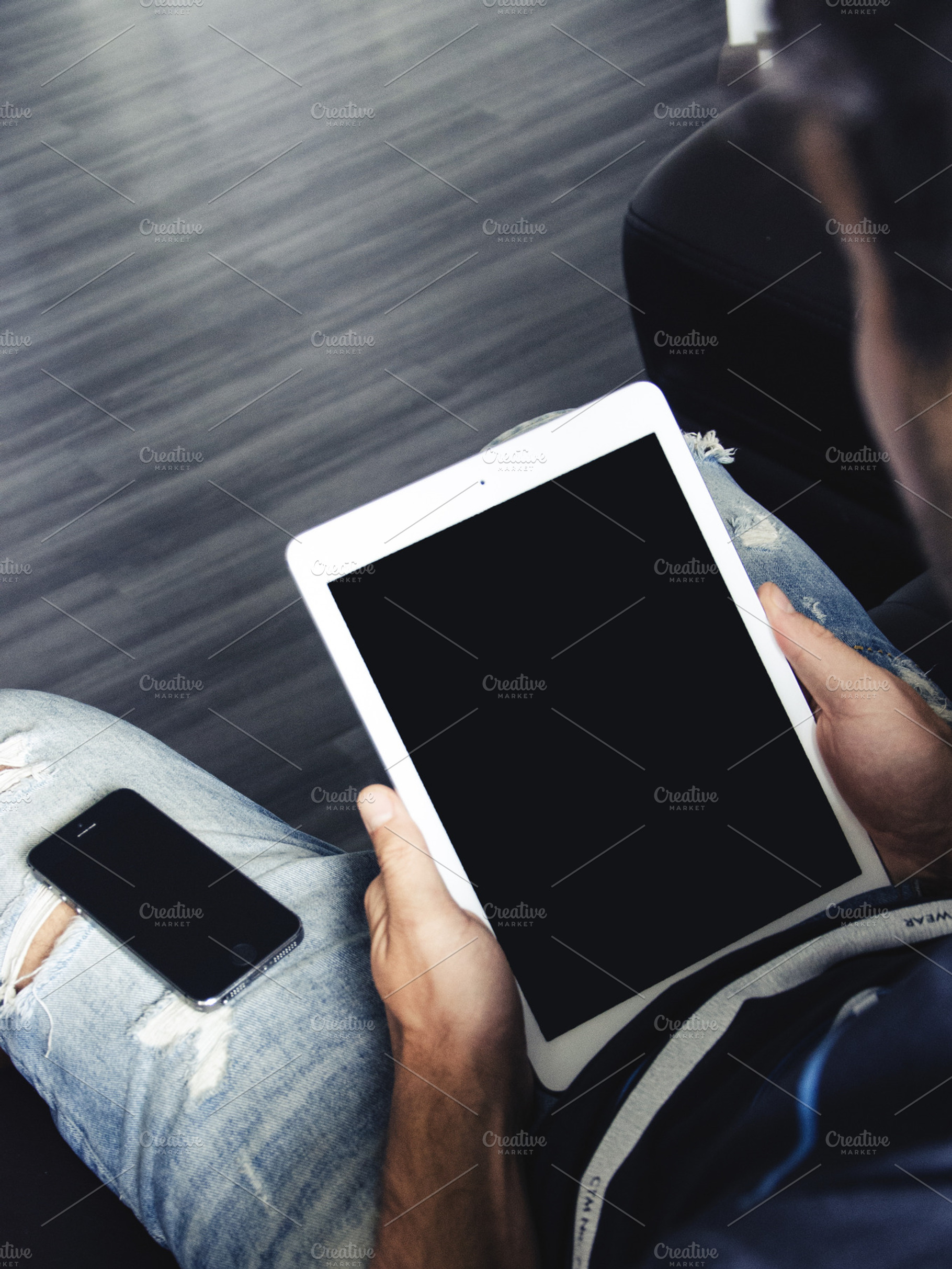 Man holding a white ipad containing mac, macbook, and laptop