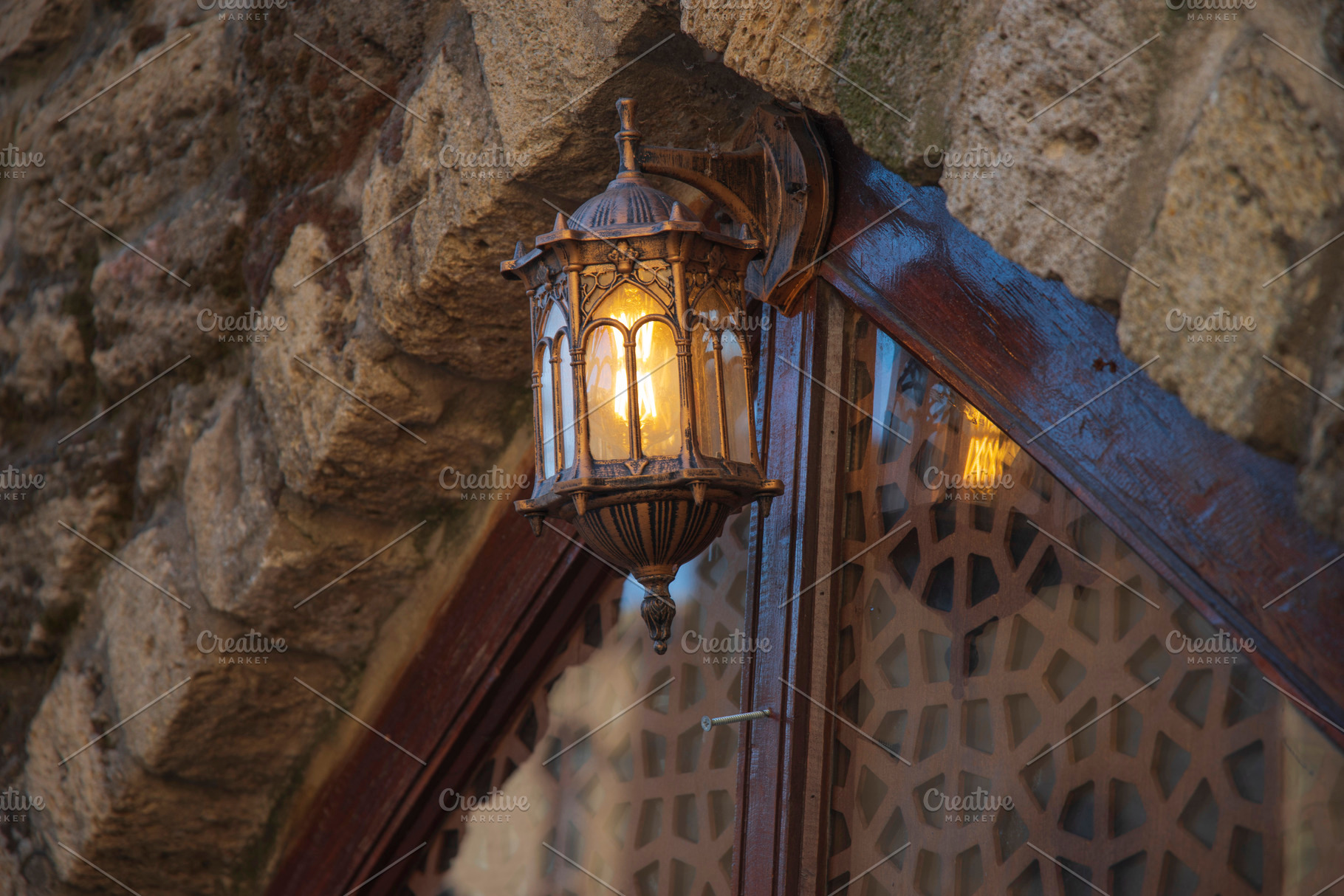 Ancient forged lantern on a stone wall in Baku with copy space, a Photo by Pictures for you!!!!!!!!!