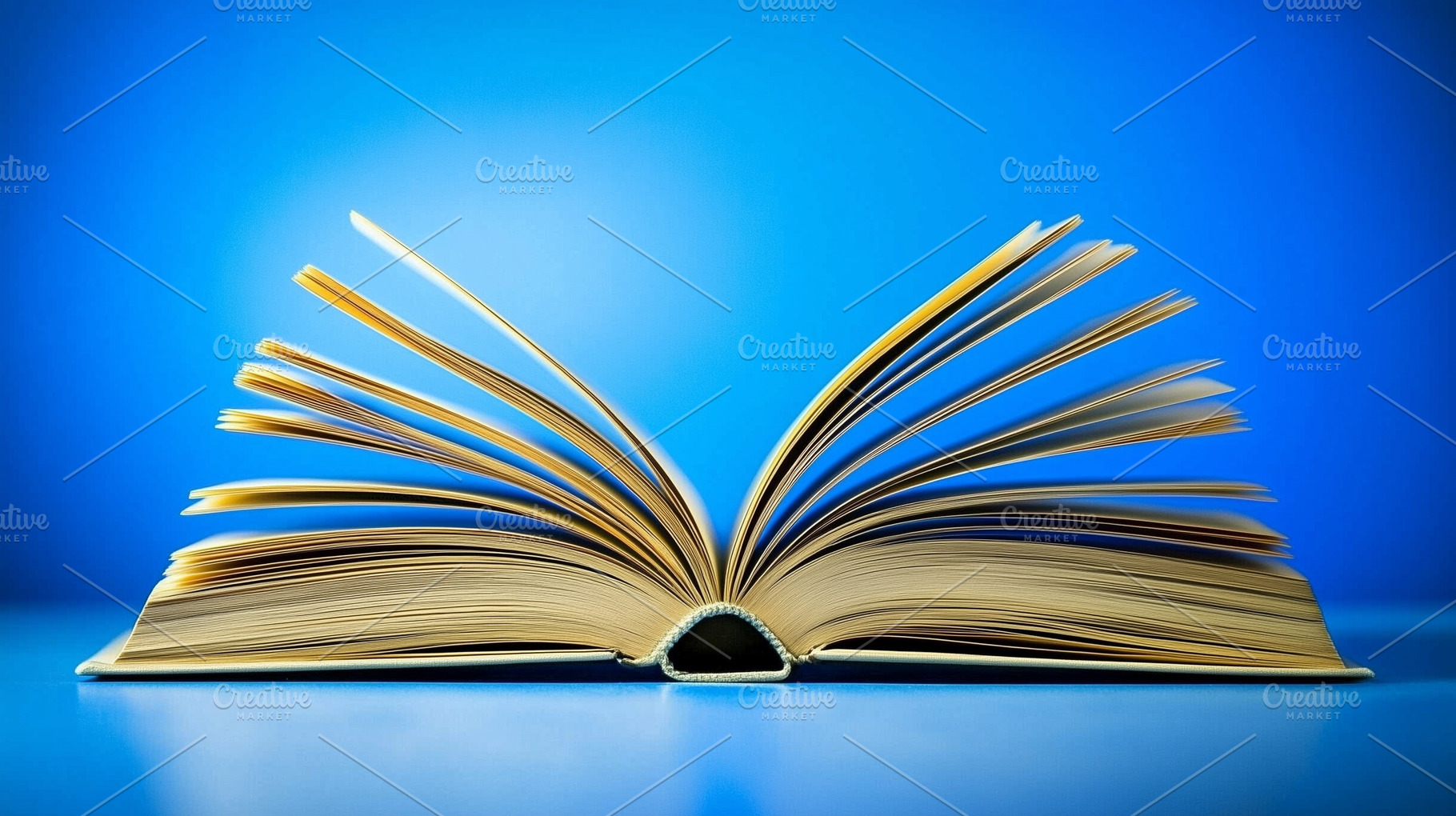 Open book on bright blue background, a School & Education Photo by MistyDay