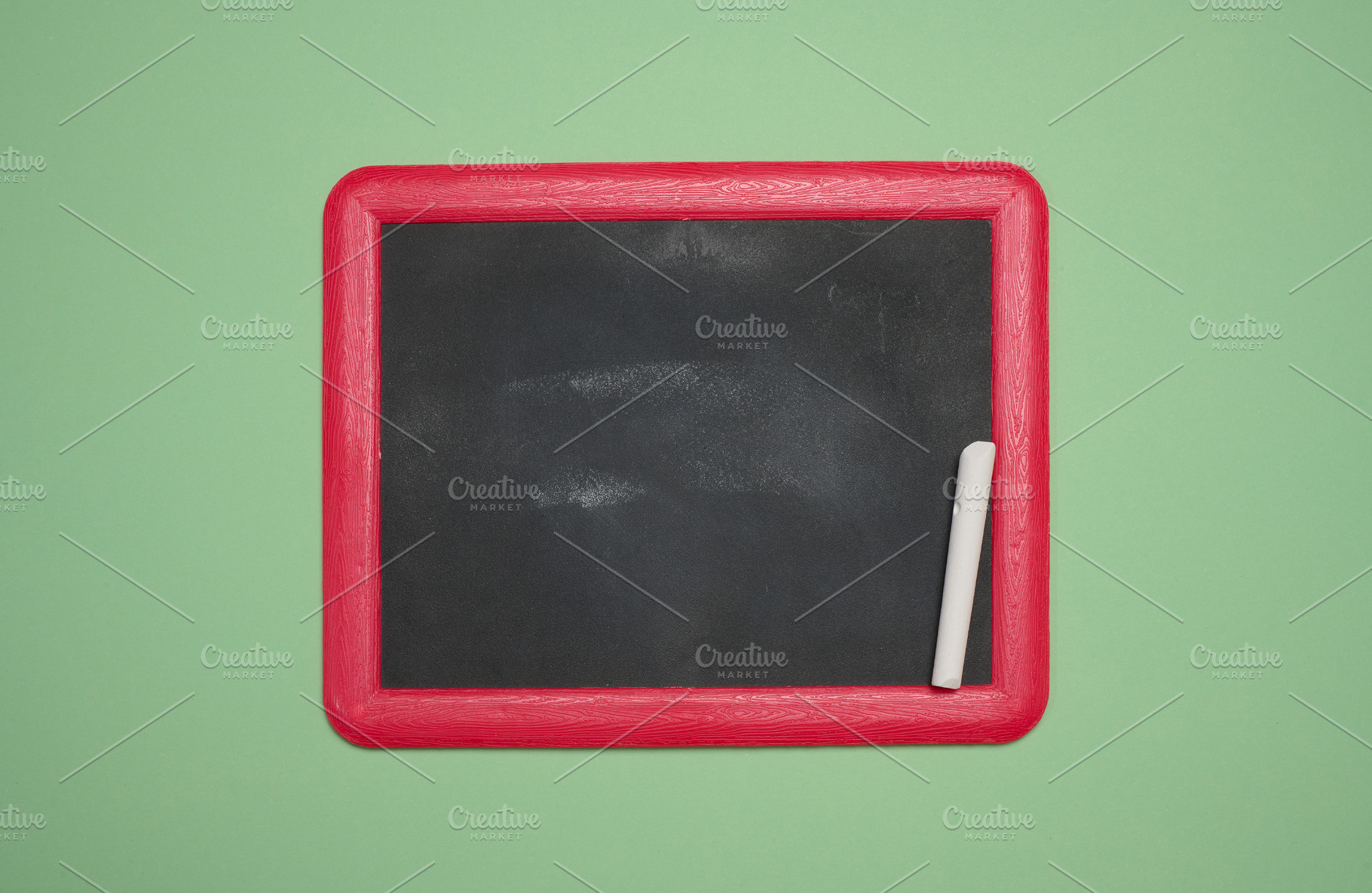 Blank chalkboard in a pink wooden frame, white chalk lying on th, a School & Education Photo by ndanko