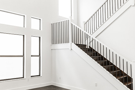 Modern white wooden staircase in new house interior with big windows