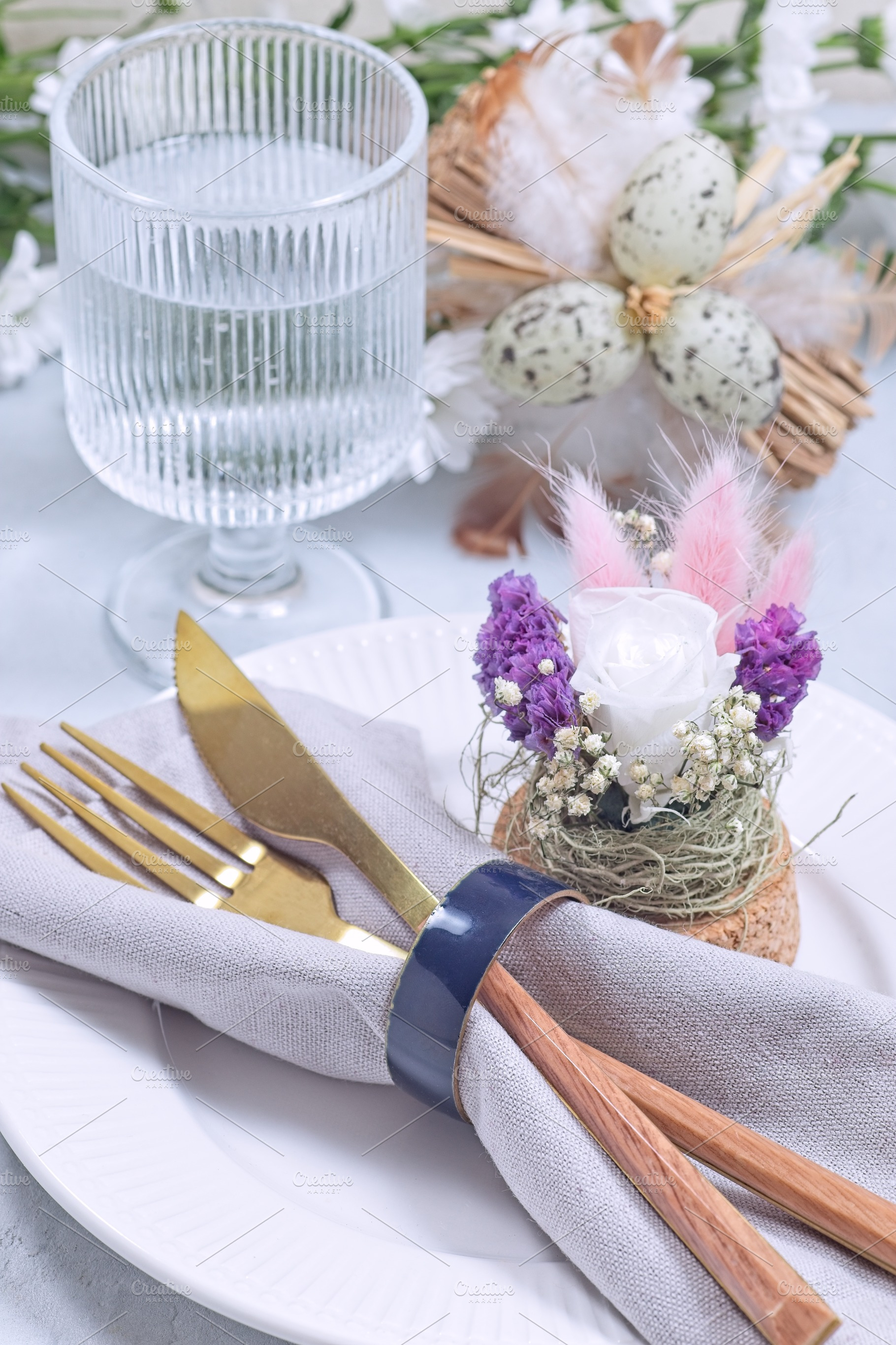 Easter table setting decorated with flower arrangement and golden cutlery, vert, a Food & Drink Photo by iuliia_n