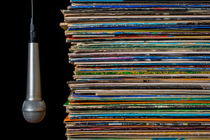 A stack of old records and hanging m containing microphone, records, and discs