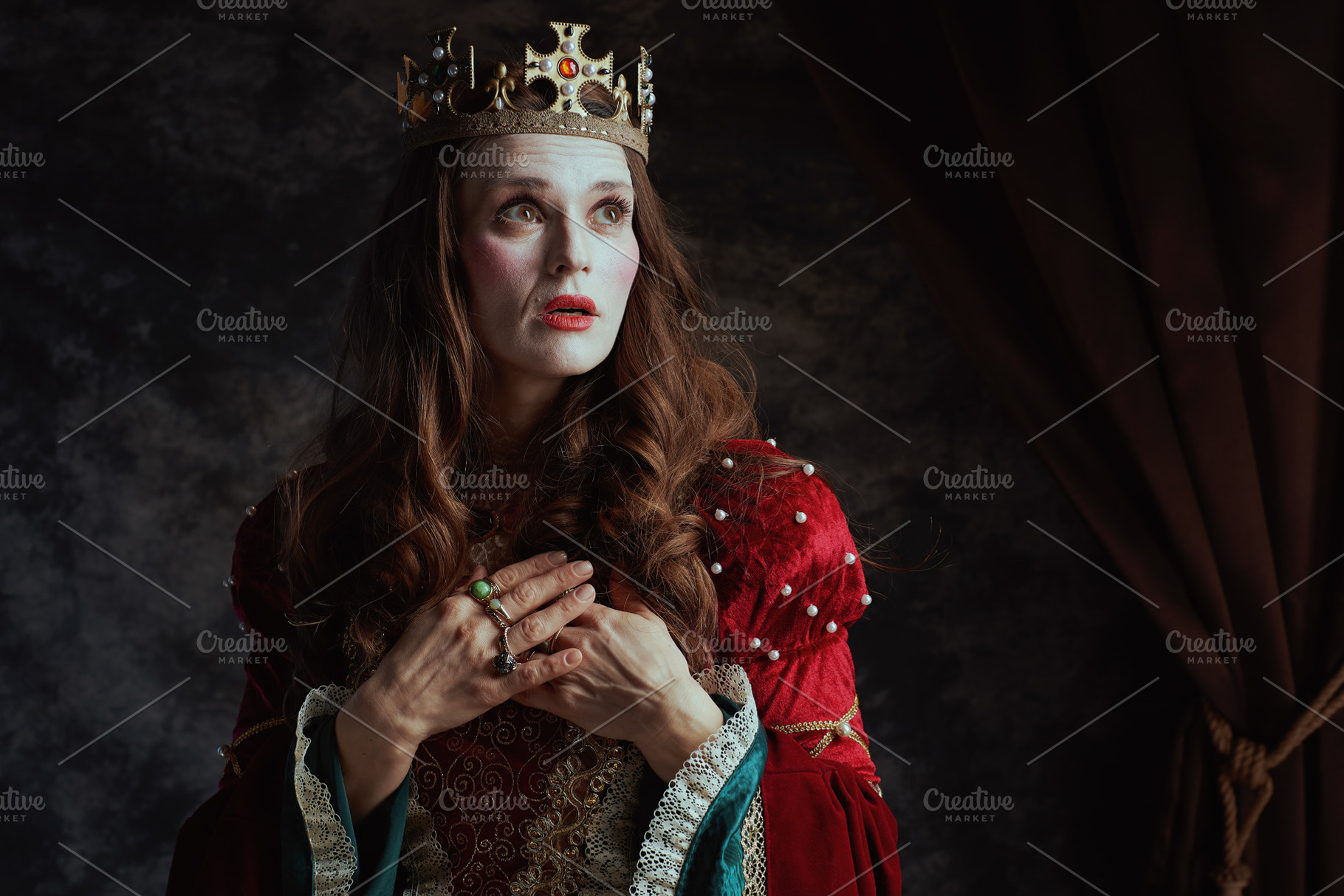 surprised medieval queen in red dress with white makeup, a Person Photo by Alliance Images