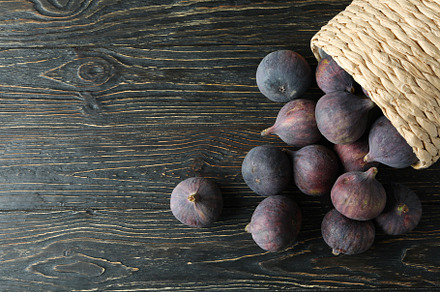 Wicker pot with fig on rustic wooden background, a Food & Drink Photo by AtlasStudio PRO