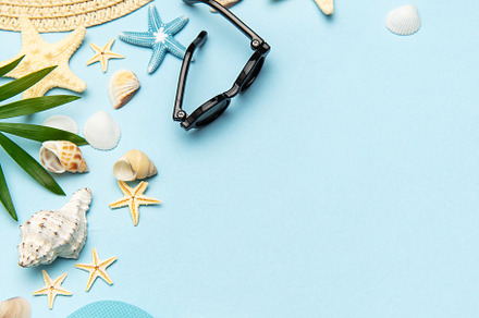 Summer accessories creating frame on light blue background with