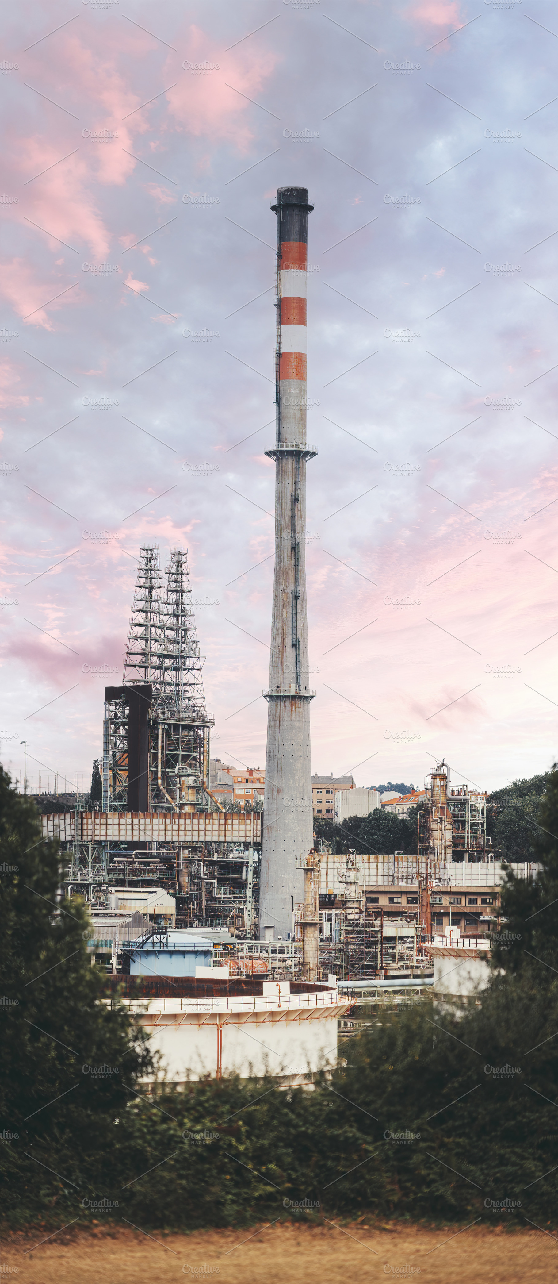 Refinery smokestack, urban backdrop, an Industrial Photo by SkyNext