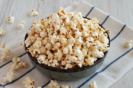 Homemade Buttered Popcorn with Salt in a Bowl, side view., a Food & Drink Photo by LiudmylaChuhunova