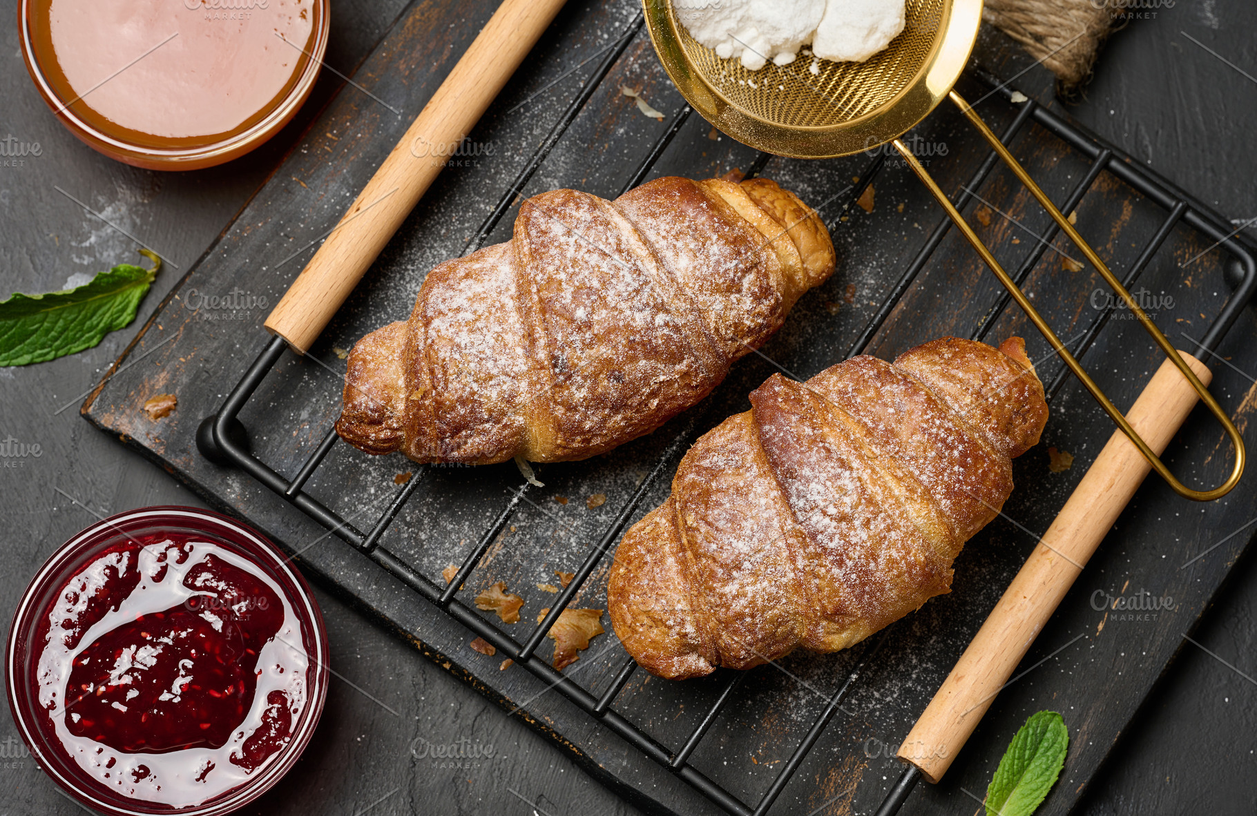 Baked croissants dusted with powdered sugar and apricot jam with, a Food & Drink Photo by ndanko