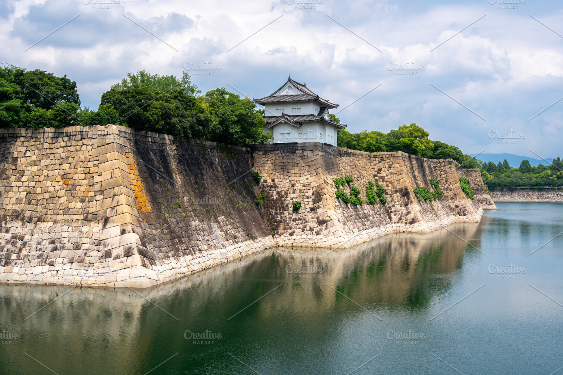 Stone walls and turret of Osaka Castle, Japan, with moat reflect, an Architecture Photo by GoodGoods