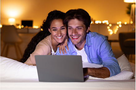 Smiling Couple Using Laptop Watching, a Person Photo by Prostock-Studio