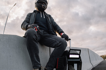 A male rider in protective gear riding an electric wheel. Urban