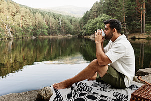 Young man drinking coffee at a picni, a Person Photo by Perpis