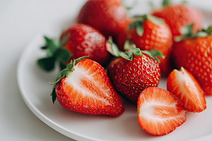 Fresh red strawberries on a white plate ready to be enjoyed or used in desserts, a Food & Drink Photo by AlyaAnd