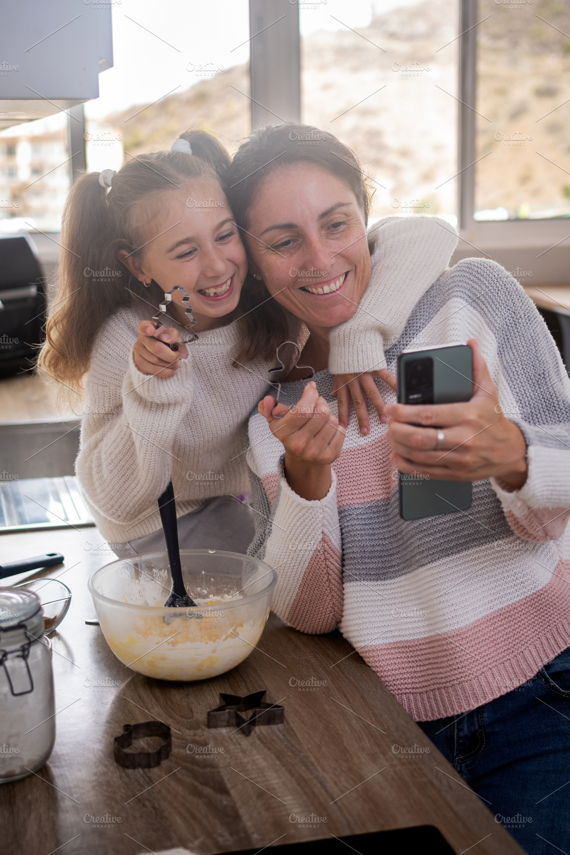 Mother and daughter taking selfie while baking Christmas cookies at home, a Person Photo by etorres69