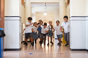 Happy elementary school children running through a school hallway, a School & Education Photo by etorres69