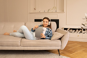 Teenage girl lounging on sofa, a Person Photo by Elena Vagengeim