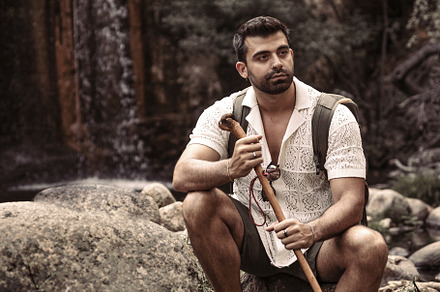 Young man sitting with hiking stick, a Person Photo by Perpis