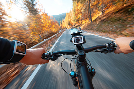 Cyclist capturing the ride with helmet-mounted action cam in scenic autumn land, a Transportation Photo by AlyaAnd
