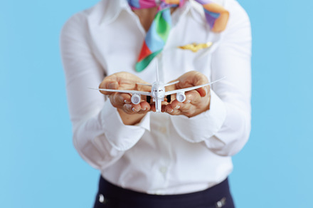 Closeup on elegant female flight attendant on blue, a Business Photo by Alliance Images