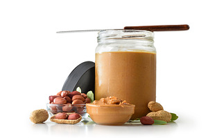 Peanut butter in a jar and peanuts on white background, a Food & Drink Photo by Davizro's Market