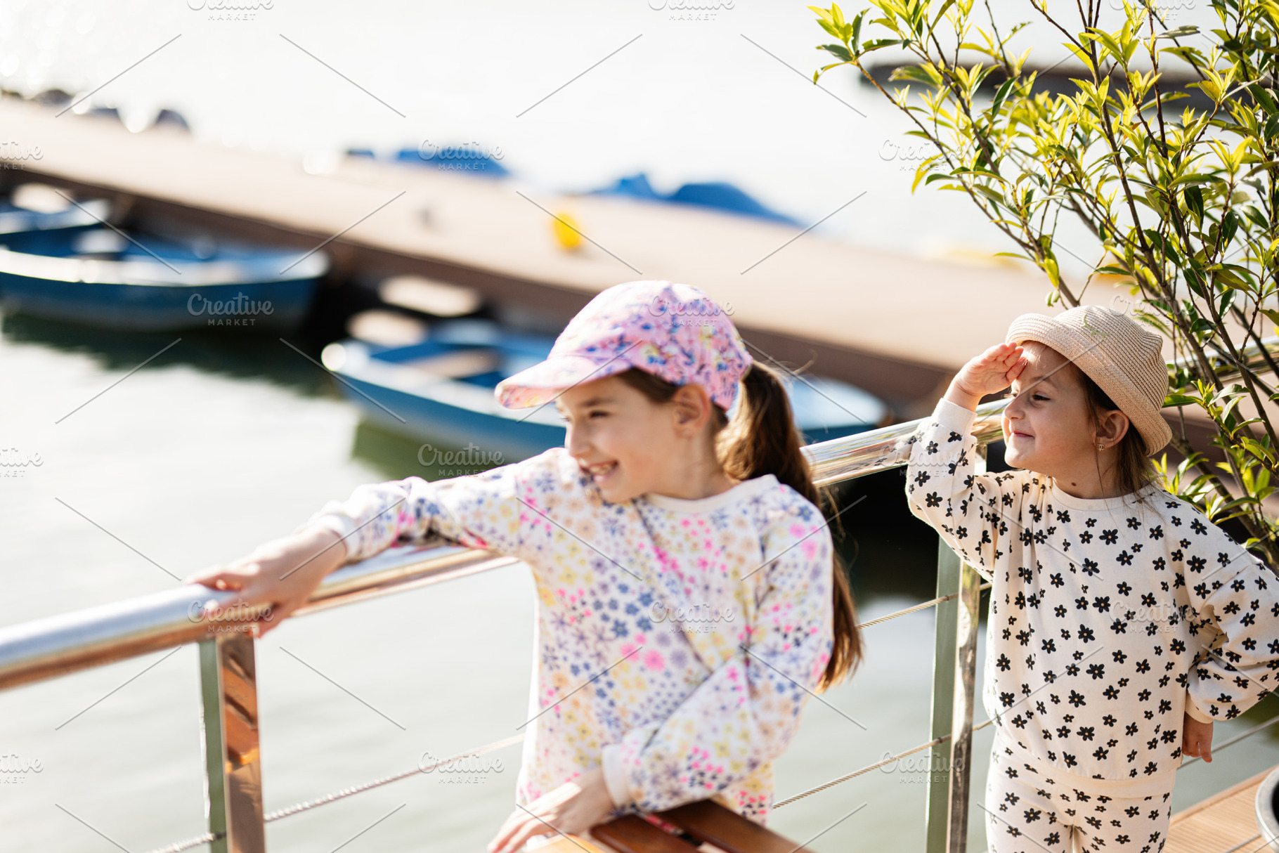 Two girls enjoying a sunny day by the water near a dock, a Person Photo by AS photostudio