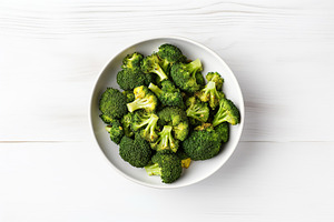 Green ripe broccoli in bowl on wooden background, a Food & Drink Photo by AlyaAnd