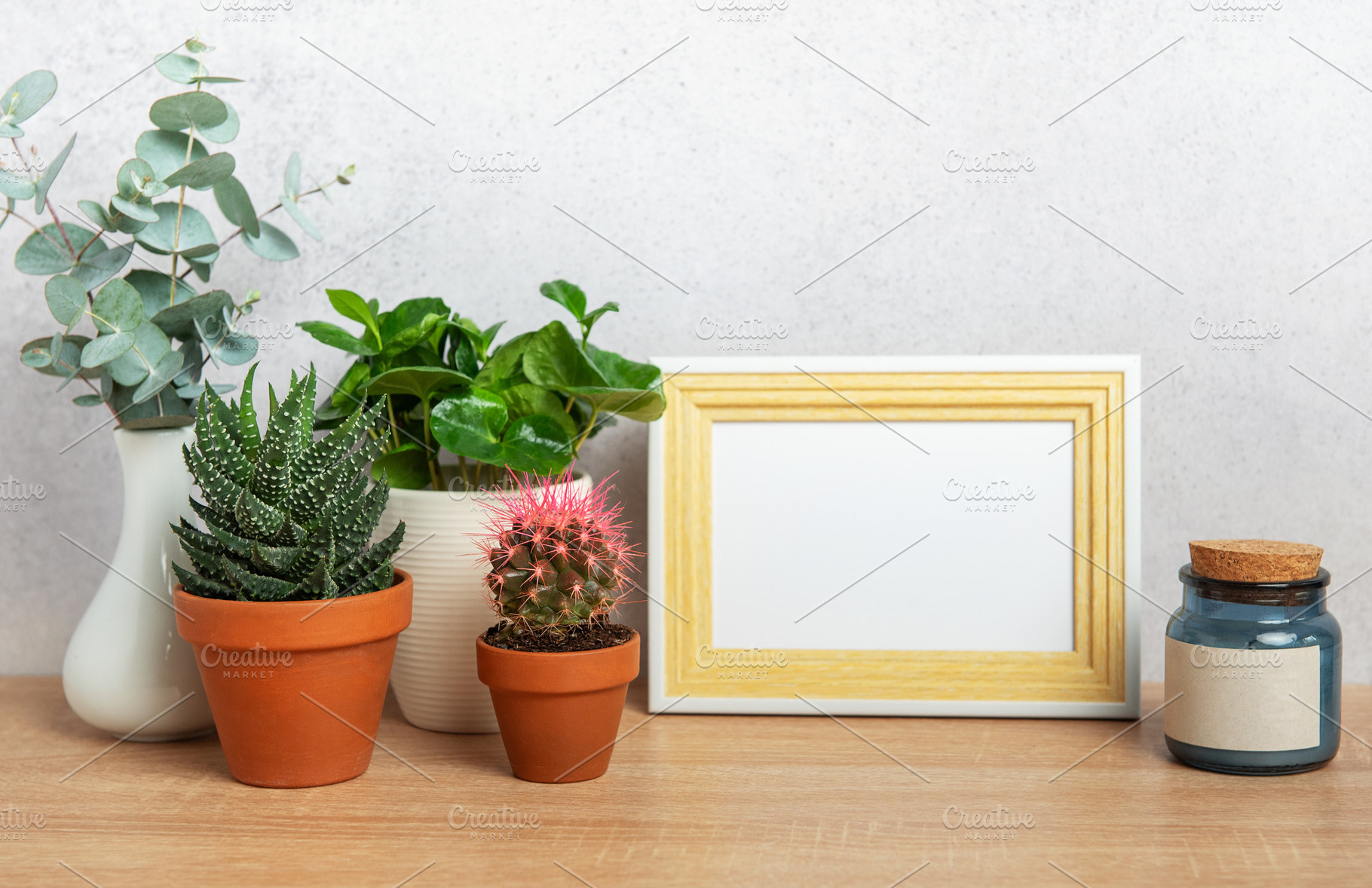 Modern home decor with blank picture frame, plants, and candle o, a Background Photo by Olena Rudo