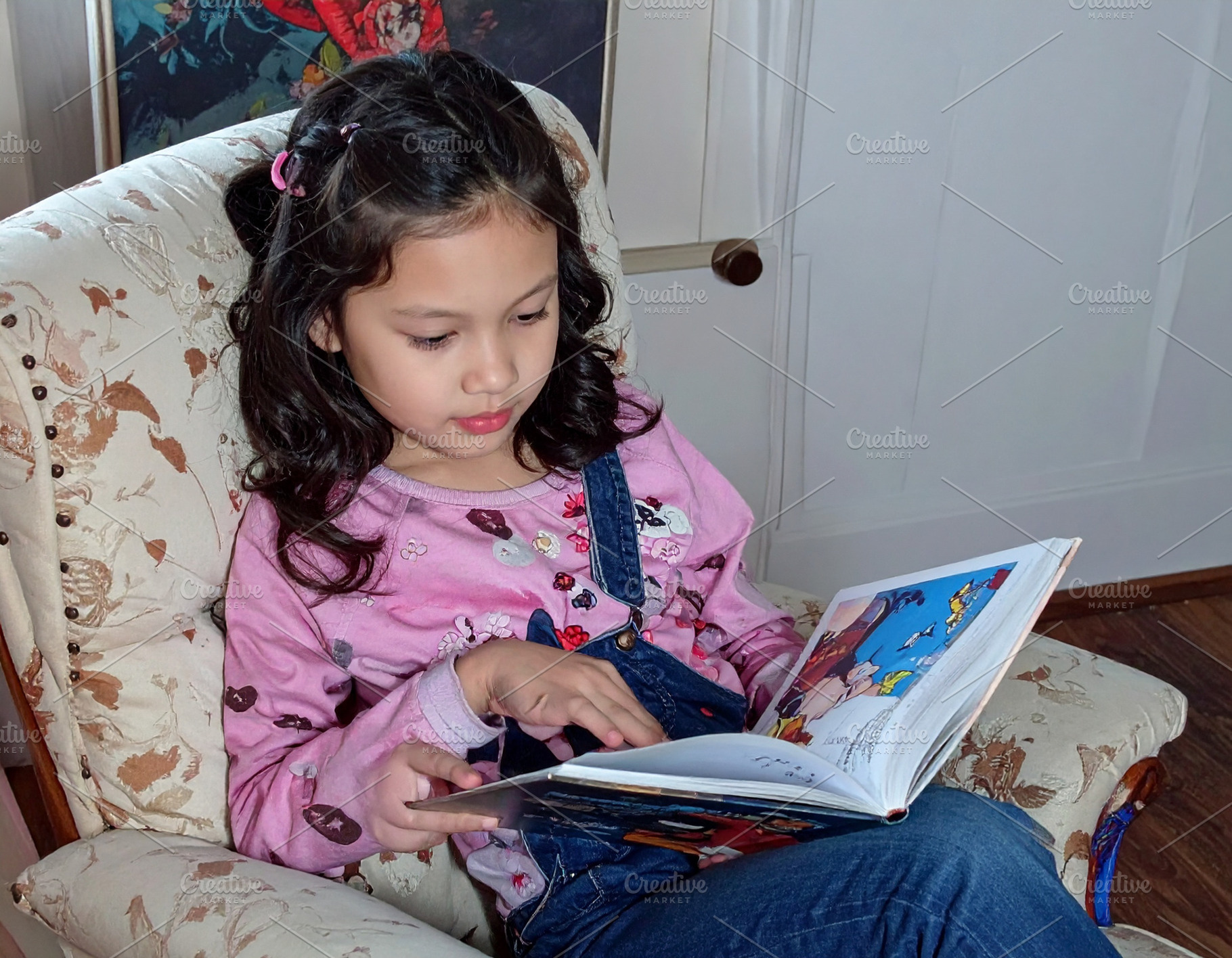 A girl reading comics at sofa, a Person Photo by DanFLCreativo