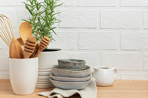 Kitchen utensils, rosemary plant, and ceramic bowls creating a c, a Food & Drink Photo by Olena Rudo