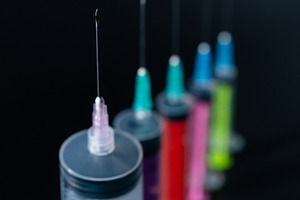 Focused Syringe Needle in a Row of Colorful Medical Supplies., a Health & Medical Photo by Rohan Photography