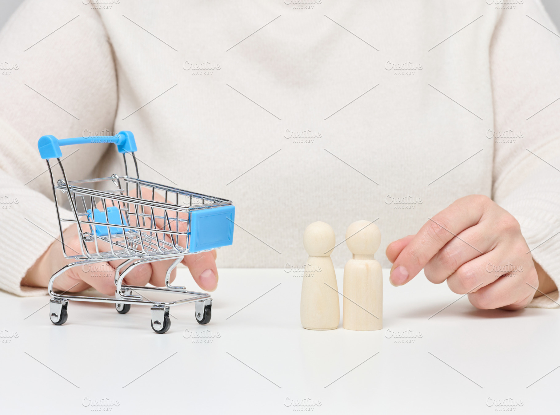 Hands are shown with a miniature shopping cart and two small woo, a Person Photo by ndanko