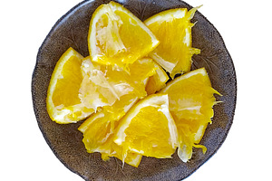 Plate with freshly cut orange slices placed on a bowl, a Food & Drink Photo by DanFLCreativo