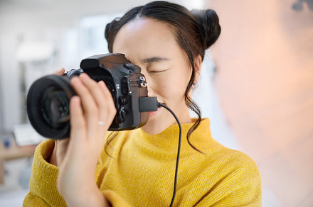 photography, camera and woman in studio shooting creative memory picture, photoshoot or digital production. Lens focus, art creativity and young Japanese photographer girl working for artistic shot, a Photo by Peopleimages.com