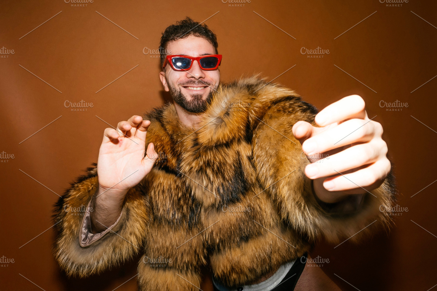 Expressive man wearing fur coat celebrating gay pride, a Photo by karrastock