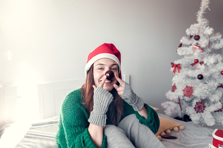 smiling girl sits on a bed against t