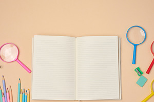 Top view of an open notebook with pastel-colored pencils, green, a School & Education Photo by ndanko