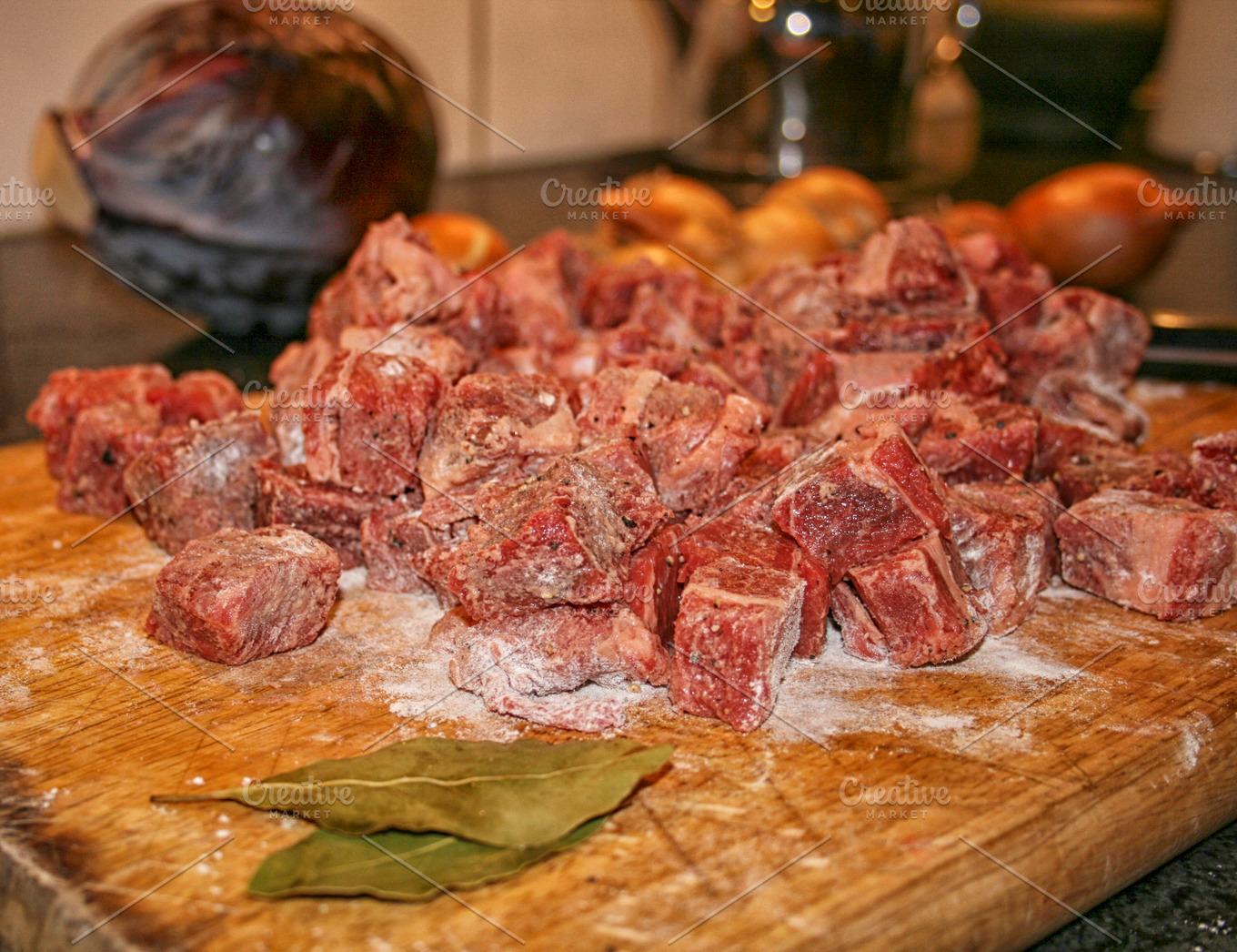 Browned beef chunks in a large pot with herbs and vegetables