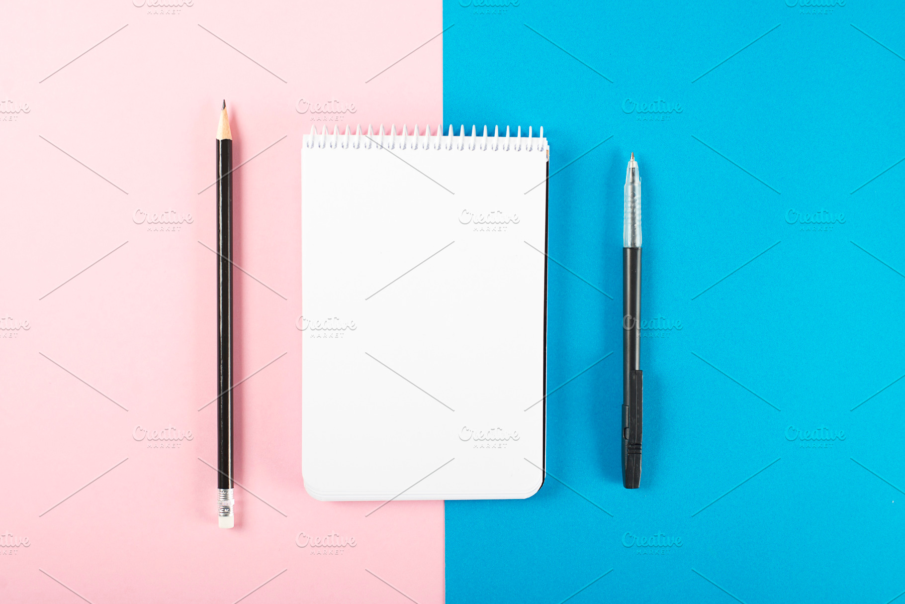 Notebook next to pencil and black pen on pink and blue background. Mockup. Stationery..., a Business Photo by José Luis Agudo