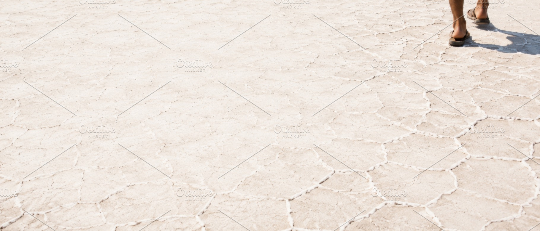 Feet walking on cracked desert groun, a Photo by Dvoevnore photos