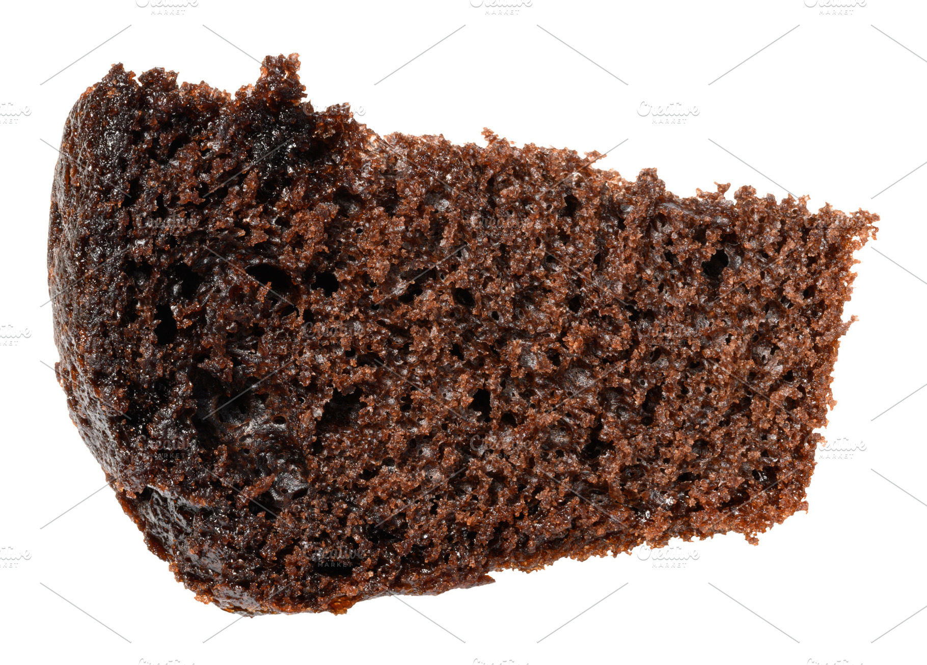 A textured, irregular piece of dark chocolate cake with a porous, a Food & Drink Photo by ndanko