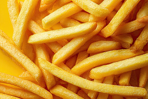 Freshly cooked golden French fries on a bright yellow background, a Food & Drink Photo by AlyaAnd