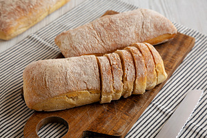 Homemade Ciabatta Bread on a wooden board, side view., a Food & Drink Photo by LiudmylaChuhunova